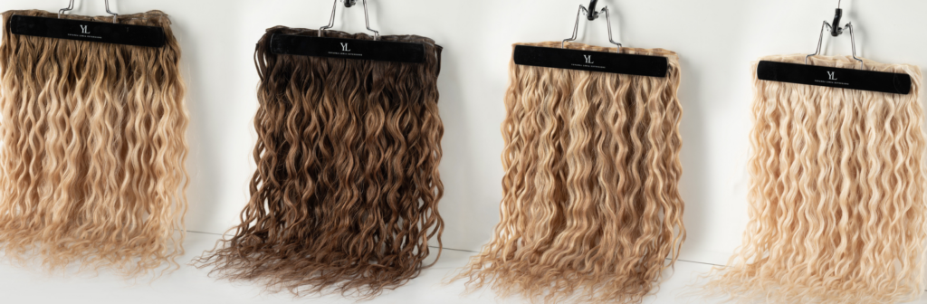 Four wavy hair extensions in different shades.